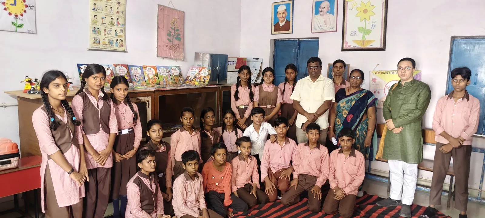 Students and SSF volunteers around a new library shelf